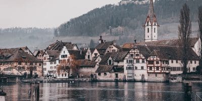 white and brown concrete house beside body of water during daytime